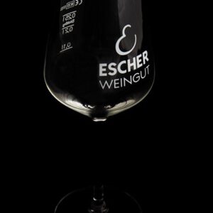 Foto eines Stil-Weinglas mit Logo des Weingut Escher vor schwarzem Hintergrund