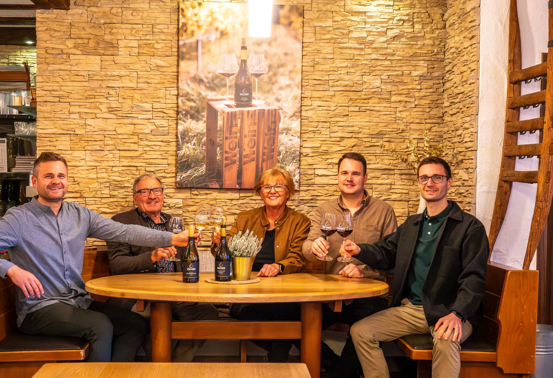 Familie Escher am Stammtisch in der Besenwirtschaft ihres Familienweingut Escher in Schwaikheim mit Weingläsern in der Hand zum Anstoßen